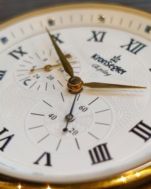 Herren Armbanduhr "Epilog" Nahaufnahme vom weißen Zifferblatt mit römischen Ziffern, Relieff und goldenen Zeigern